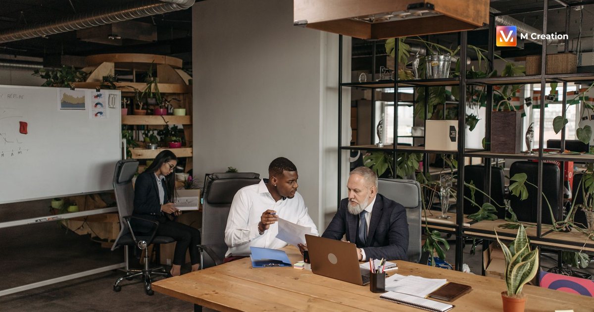 A diverse group of professionals discussing work documents in a contemporary office setting.