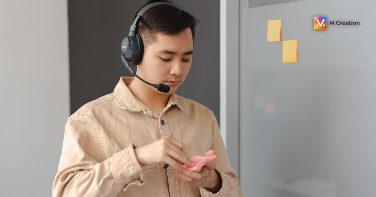 Young adult in an office setting using a headset and sticky notes. Ideal for business communication visuals.
