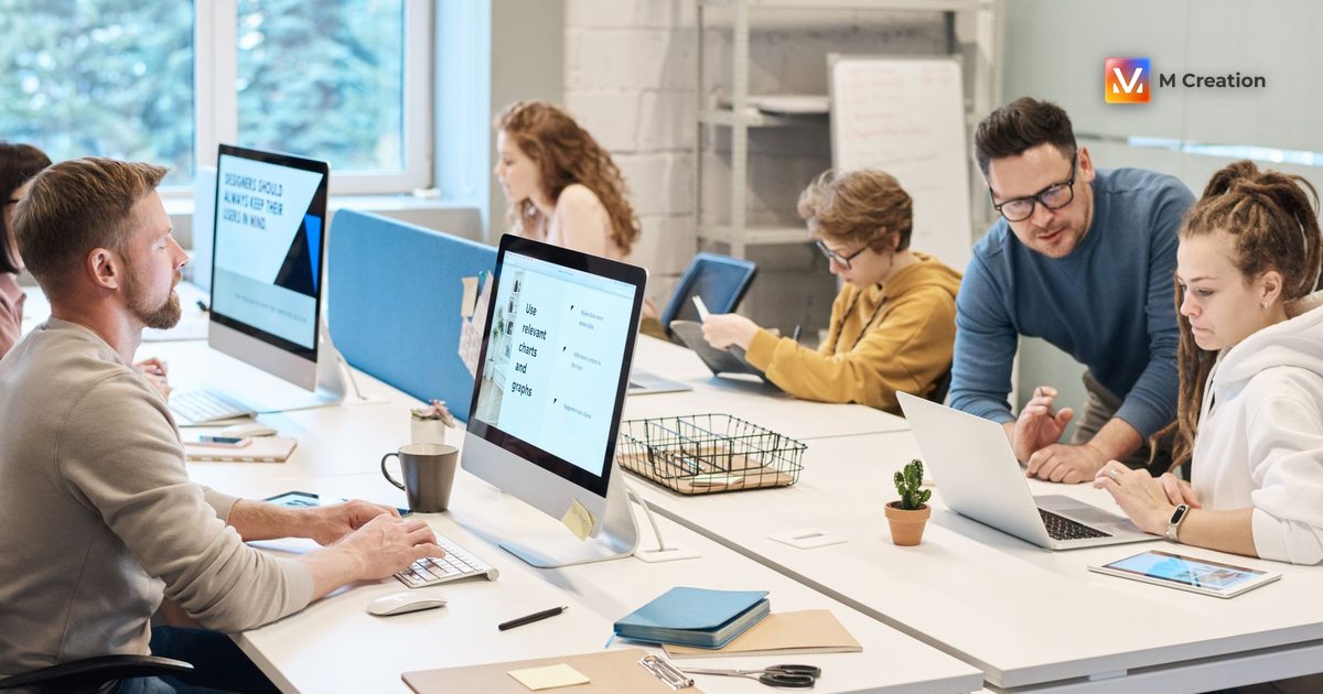Team collaboration in a modern office setting with computers and diverse employees working together.